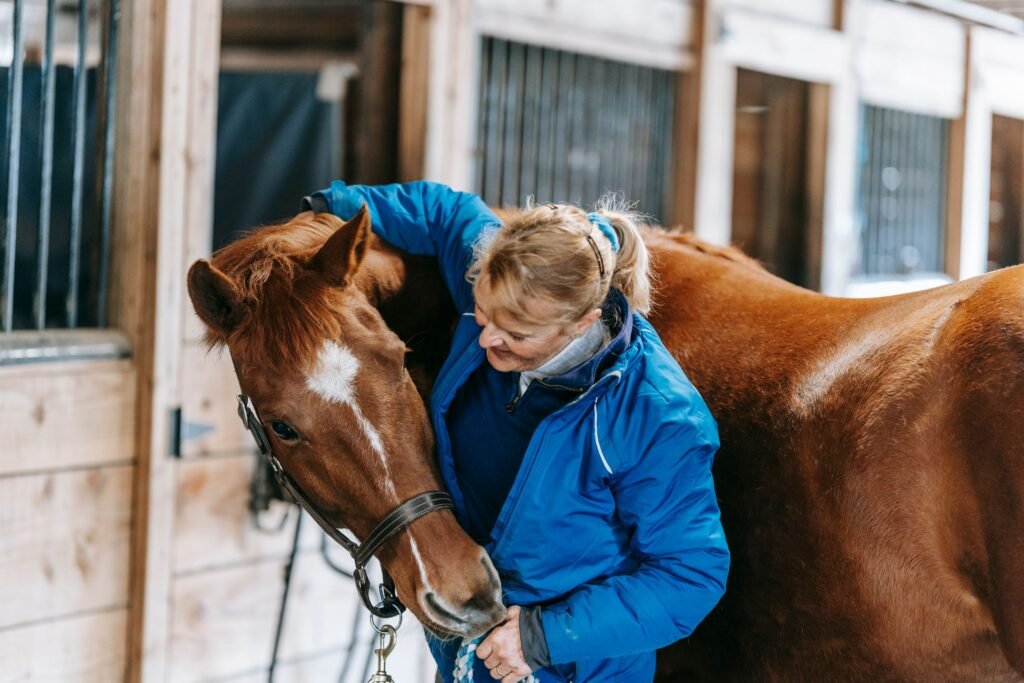 A woman embracing a horse inside a rustic stable